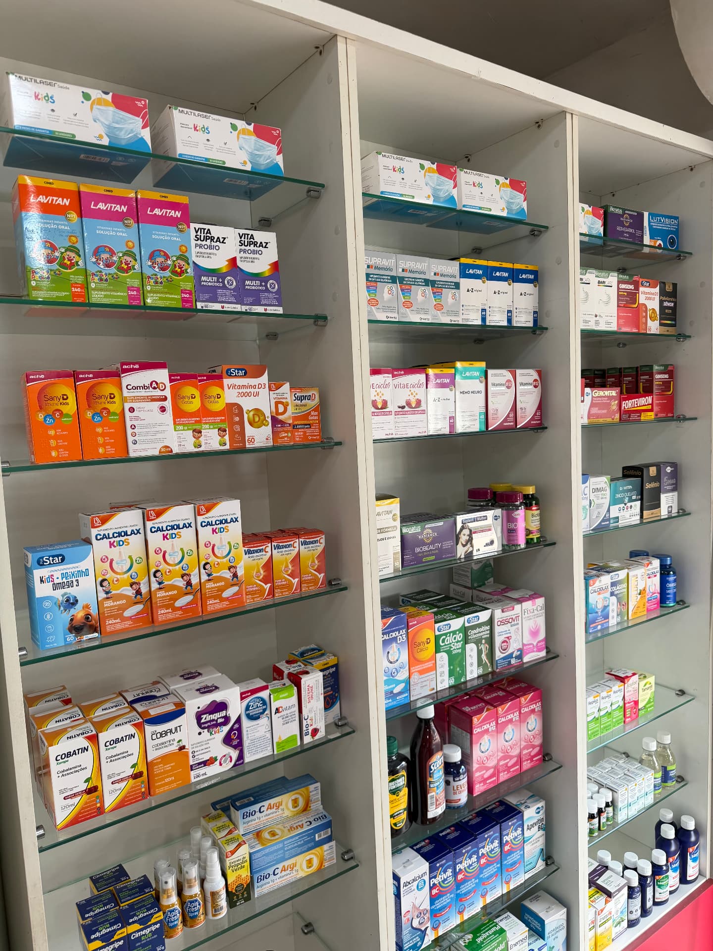Estante de vidro com vitaminas e suplementos organizados